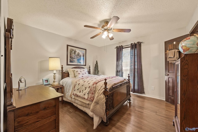 bedroom with a textured ceiling, ceiling fan, and dark hardwood / wood-style floors