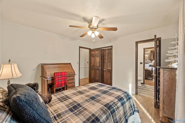 bedroom featuring ceiling fan, a closet, light hardwood / wood-style floors, and a textured ceiling