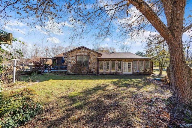 rear view of house with a lawn and french doors