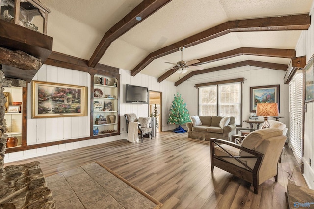 living room featuring a textured ceiling, built in features, a wealth of natural light, and vaulted ceiling