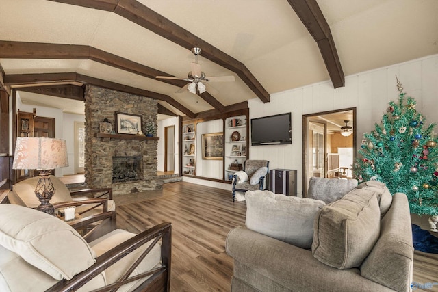 living room with a stone fireplace, ceiling fan, lofted ceiling with beams, and hardwood / wood-style flooring