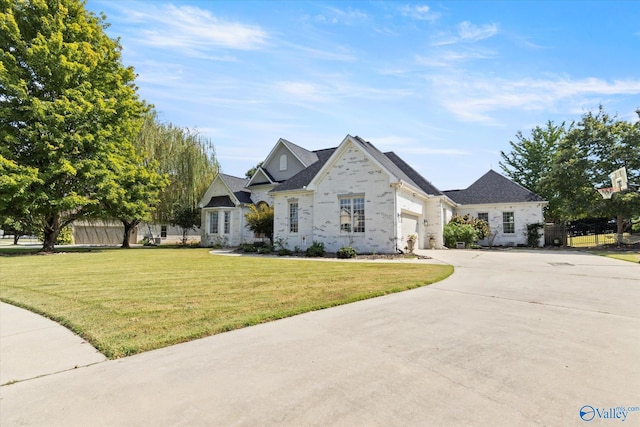 french provincial home with a front lawn and a garage