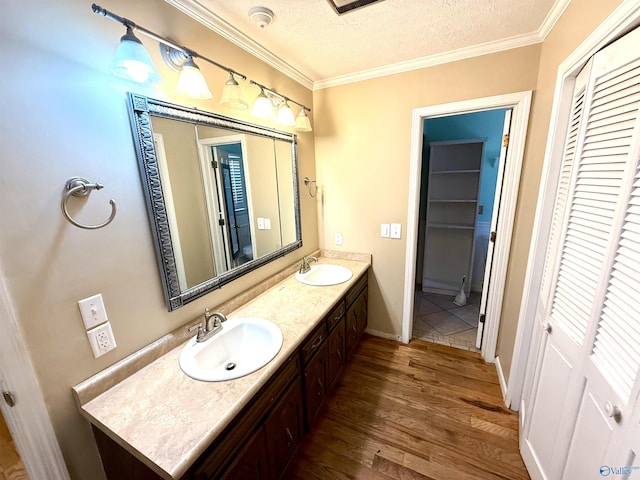 bathroom with a closet, a textured ceiling, wood finished floors, and a sink