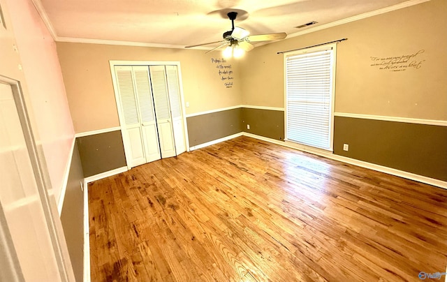 unfurnished bedroom with baseboards, wood finished floors, a closet, and ornamental molding