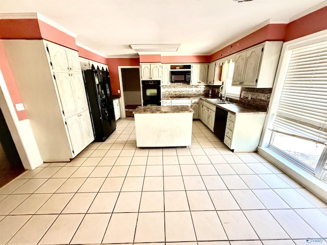 kitchen with a kitchen island, light tile patterned flooring, a sink, black appliances, and backsplash