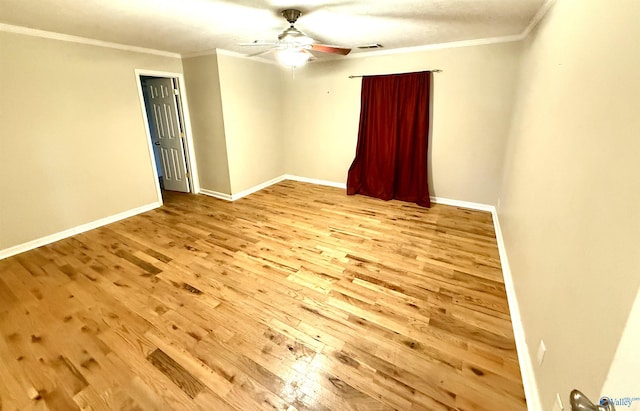 spare room featuring baseboards, crown molding, ceiling fan, and wood finished floors