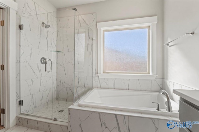 full bath featuring a garden tub, a marble finish shower, and vanity