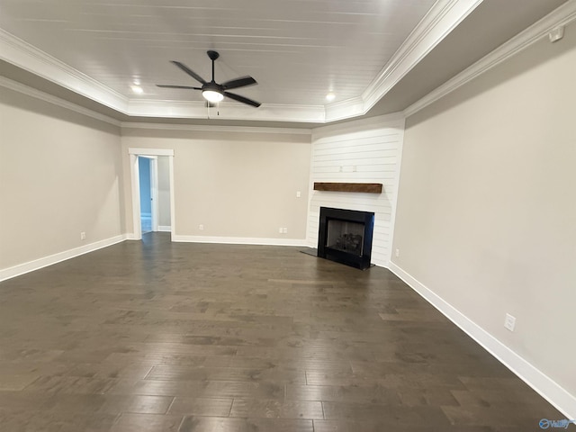 unfurnished living room with ornamental molding, a raised ceiling, ceiling fan, and dark wood-style flooring