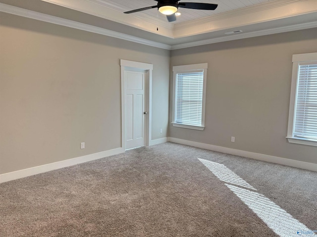 unfurnished room featuring a ceiling fan, baseboards, carpet, a raised ceiling, and crown molding