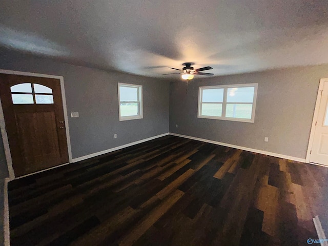 entrance foyer with dark wood-type flooring, ceiling fan, a healthy amount of sunlight, and a textured ceiling