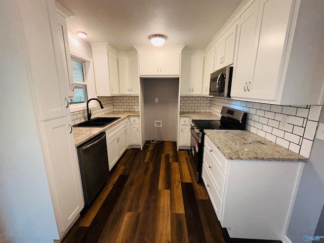 kitchen with stainless steel appliances, sink, light stone countertops, dark hardwood / wood-style floors, and white cabinets