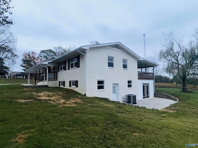 rear view of house featuring central air condition unit, a patio, and a yard