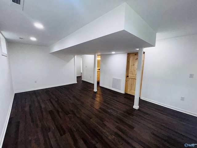 basement with dark hardwood / wood-style flooring