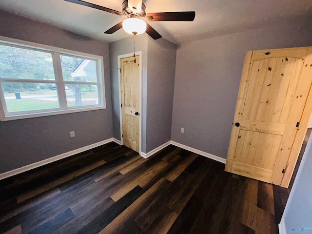 unfurnished bedroom with ceiling fan and dark hardwood / wood-style floors