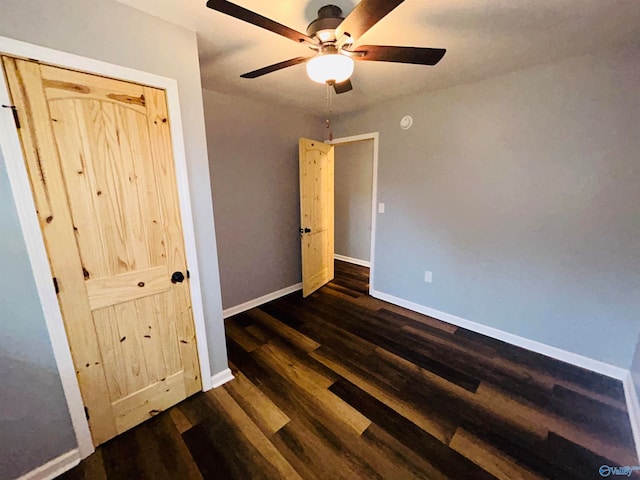 unfurnished bedroom featuring dark wood-type flooring and ceiling fan