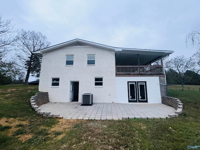 back of house with a patio and a lawn