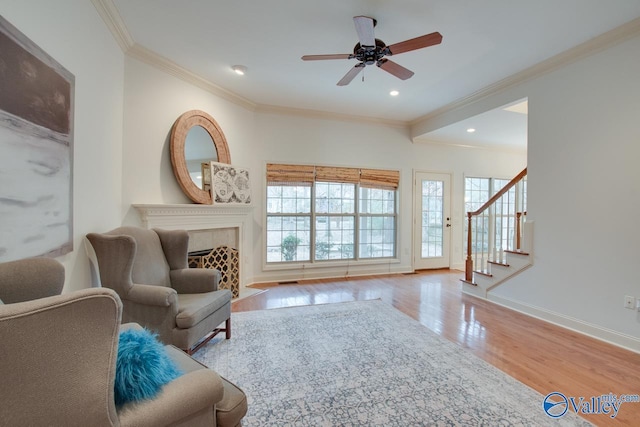 sitting room with light hardwood / wood-style floors, ceiling fan, and ornamental molding