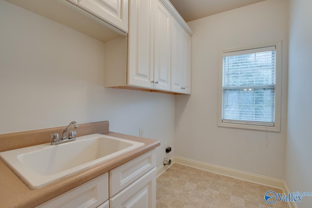 laundry room featuring sink and cabinets