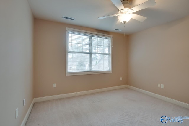 spare room featuring light colored carpet and ceiling fan