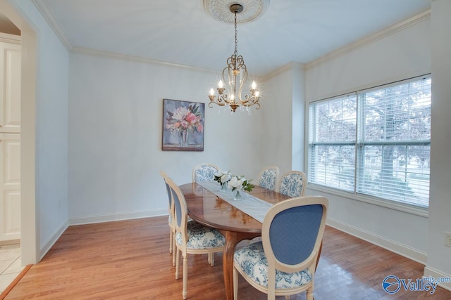 dining space featuring light hardwood / wood-style floors, crown molding, and a notable chandelier