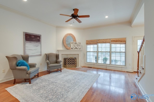 sitting room with ceiling fan, light wood-type flooring, and ornamental molding