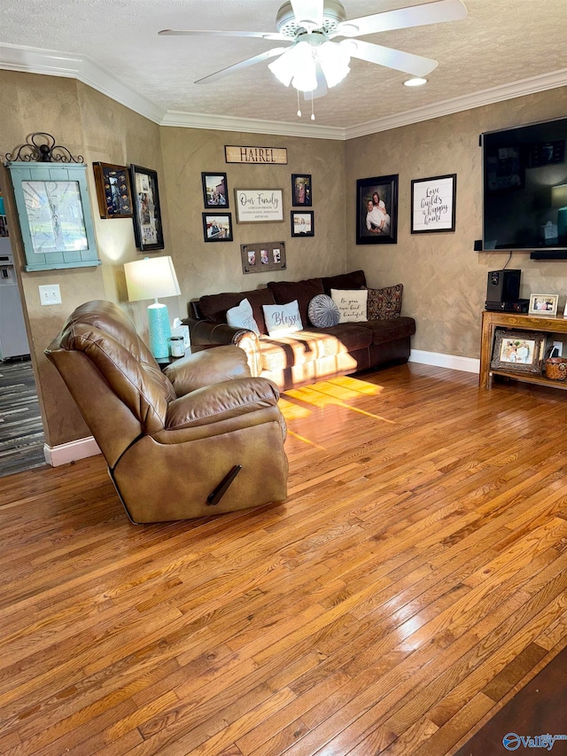 living room with ceiling fan, crown molding, and hardwood / wood-style flooring