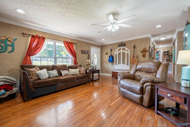 living room with hardwood / wood-style flooring, a textured ceiling, crown molding, and ceiling fan