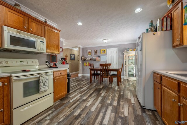 kitchen featuring a textured ceiling, white appliances, crown molding, and dark hardwood / wood-style flooring