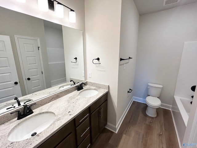 bathroom with hardwood / wood-style flooring, vanity, and toilet