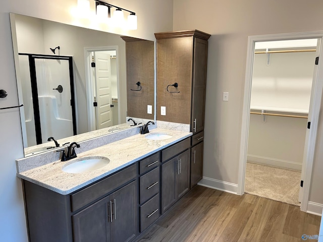 bathroom with hardwood / wood-style flooring, vanity, and a shower with shower door