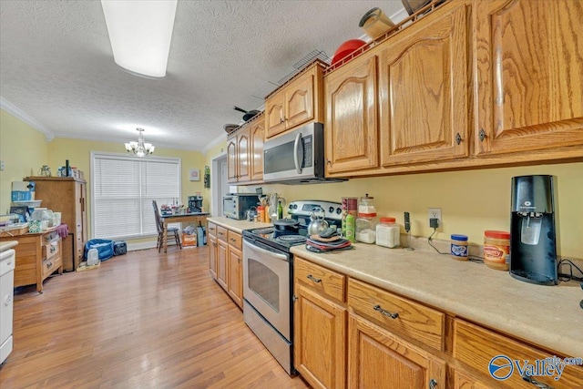 23311 Toone Rd, Elkmont, AL 35620 - kitchen with light countertops, light wood-type flooring, ornamental molding, a chandelier, and appliances with stainless steel finishes