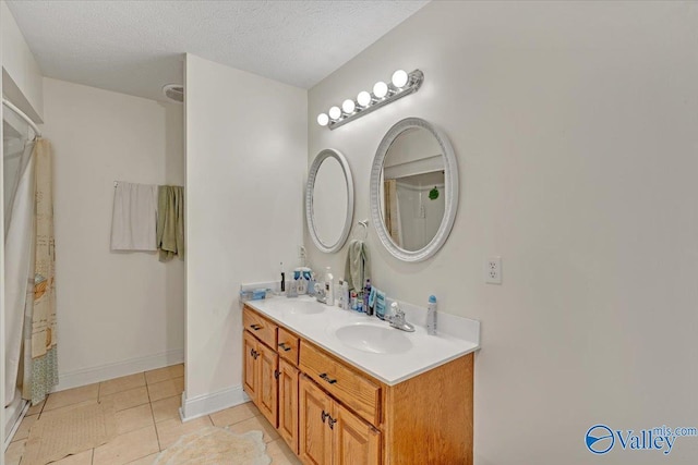 23311 Toone Rd, Elkmont, AL 35620 - full bathroom featuring double vanity, tile patterned flooring, a sink, and a textured ceiling