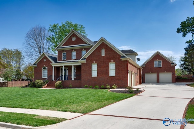 traditional-style house featuring covered porch, fence, a front lawn, brick siding, and driveway