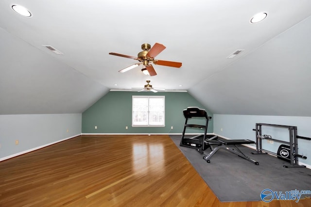 exercise area with visible vents, baseboards, and vaulted ceiling