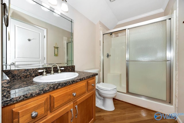 bathroom featuring crown molding, vanity, toilet, wood finished floors, and a stall shower