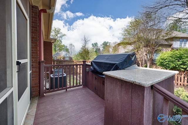 wooden deck featuring central air condition unit and grilling area