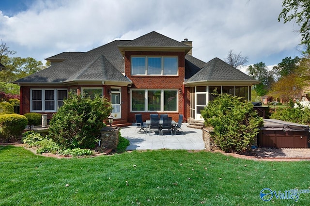 rear view of property featuring entry steps, a yard, a patio, and a hot tub