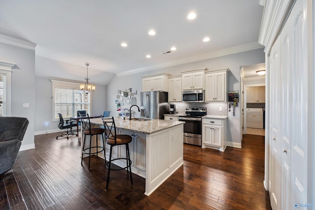 kitchen with stainless steel appliances, light stone counters, backsplash, a kitchen island with sink, and dark hardwood / wood-style flooring