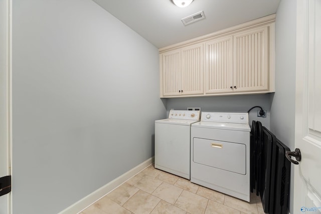 clothes washing area featuring cabinets, light tile patterned floors, and independent washer and dryer