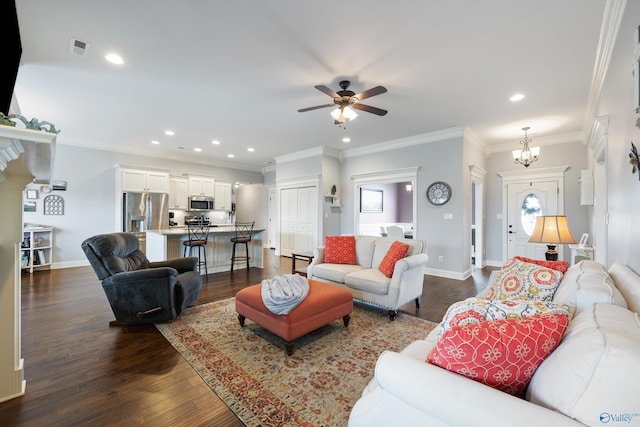 living room with ornamental molding, dark hardwood / wood-style floors, and ceiling fan with notable chandelier