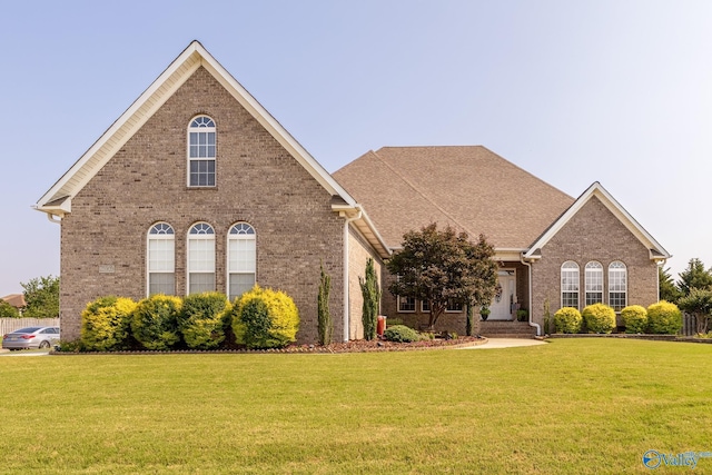 view of front facade with brick siding and a front yard