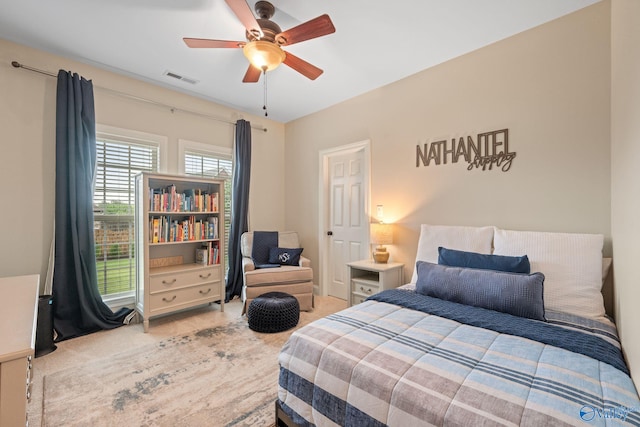 carpeted bedroom with visible vents and a ceiling fan