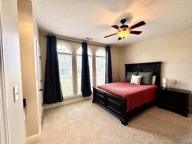 bedroom featuring visible vents, ceiling fan, baseboards, and light carpet