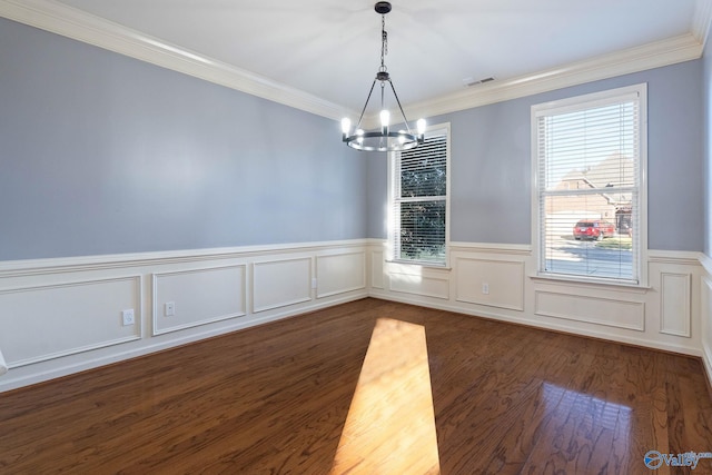 empty room with crown molding, dark hardwood / wood-style floors, and a notable chandelier