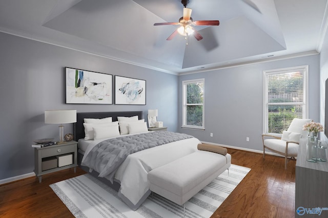 bedroom with dark wood-type flooring, ceiling fan, a raised ceiling, and crown molding