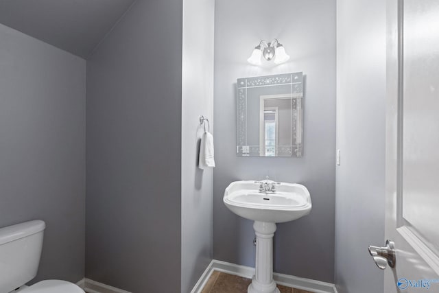 bathroom with lofted ceiling, toilet, and tile patterned flooring