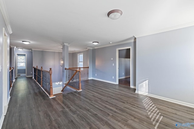 spare room featuring ornamental molding, ornate columns, and dark hardwood / wood-style floors