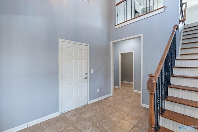 foyer with a high ceiling and light tile patterned flooring