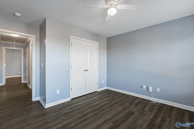 unfurnished bedroom featuring dark wood-type flooring, ceiling fan, a closet, and crown molding