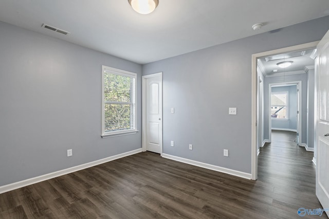 empty room with dark wood-type flooring and ornamental molding